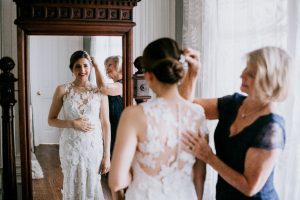 A bride smiling looking in the mirror.